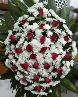 Coroa Gota com Rosas — coroa de flores em Salvador. Coroa em formato de gota, com rosas vermelhas e crisântemos brancos.