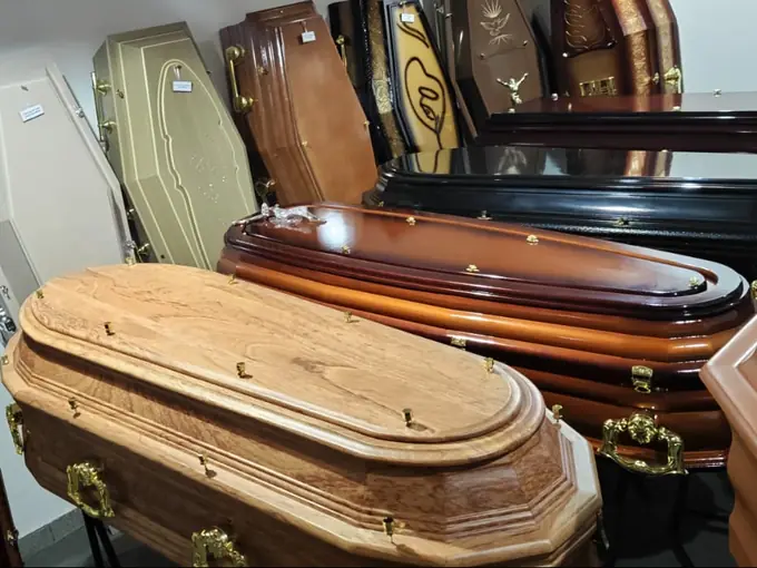 Urnas em madeira e acabamento claro na loja da Funerária Villas